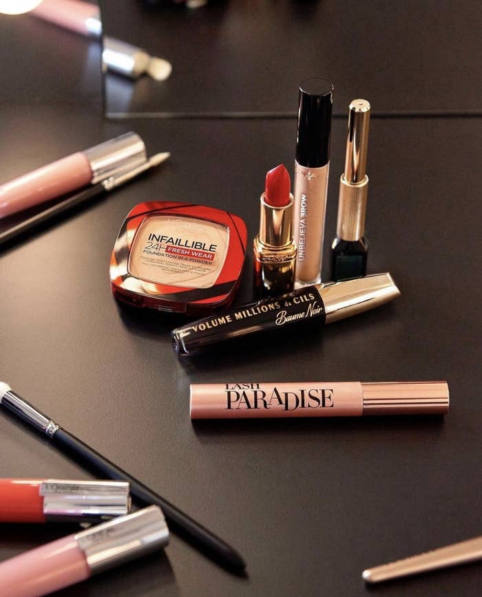 A foundation compact, lipsticks, makeup brushes, and lip glosses