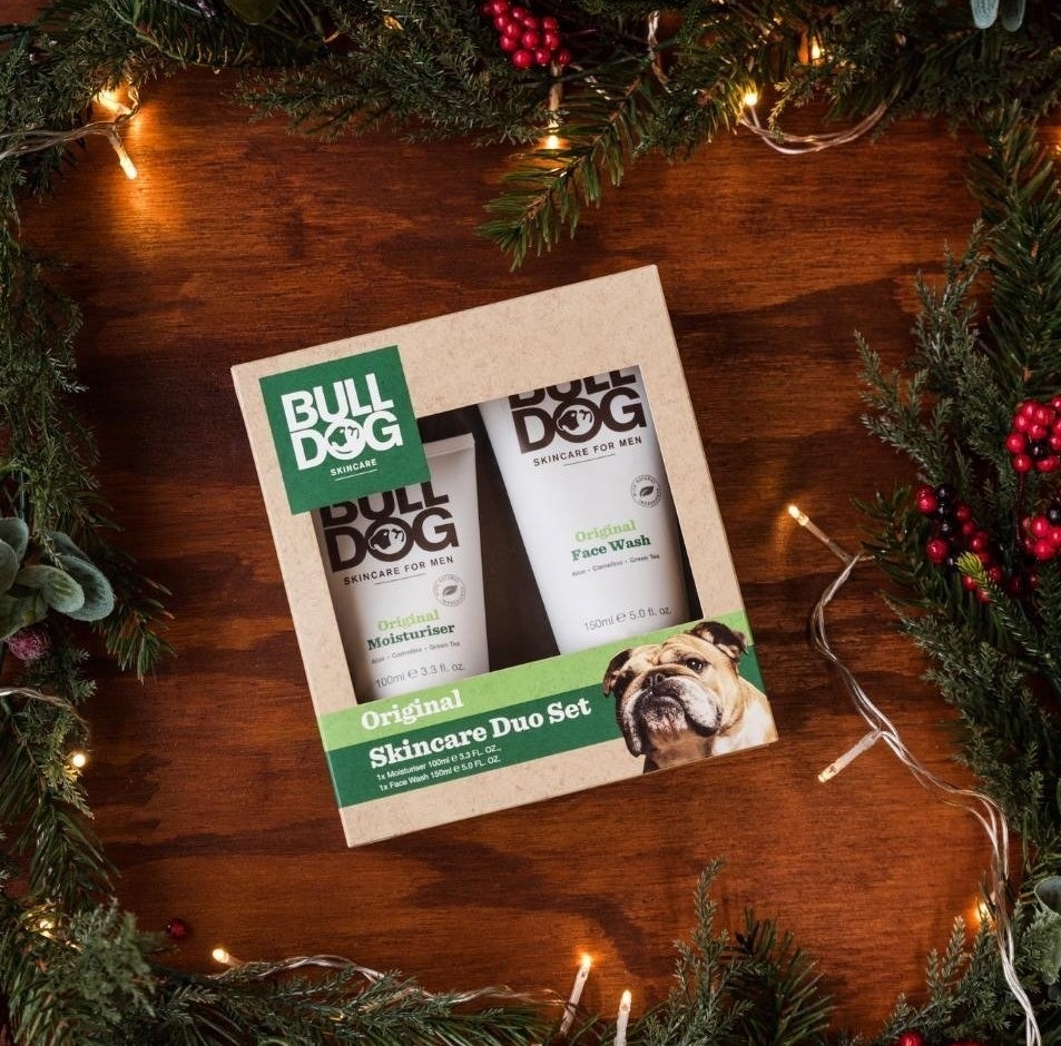 a boxed set of face wash and moisturizer surrounded by holiday decor
