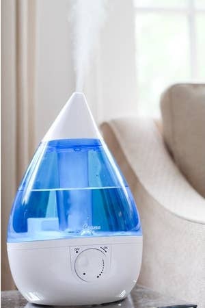 lifestyle image of the blue Crane droplet humidifier with steam coming out