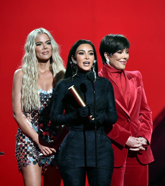 Kim standing onstage with her mother and sister Khloe
