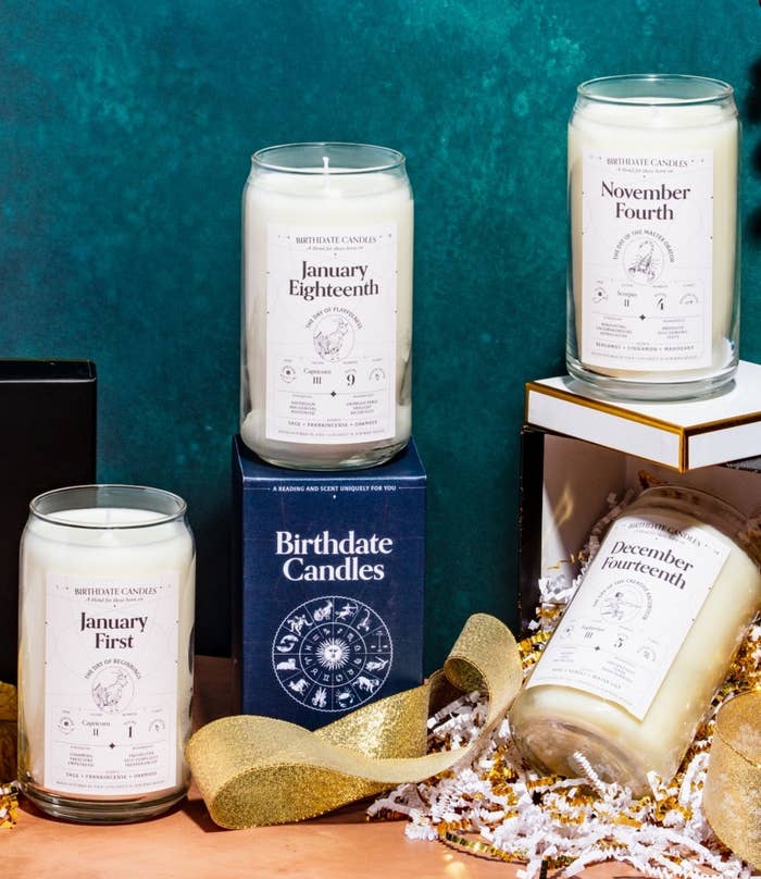 Five of the birthdate candles arranged around various gift boxes and packaging