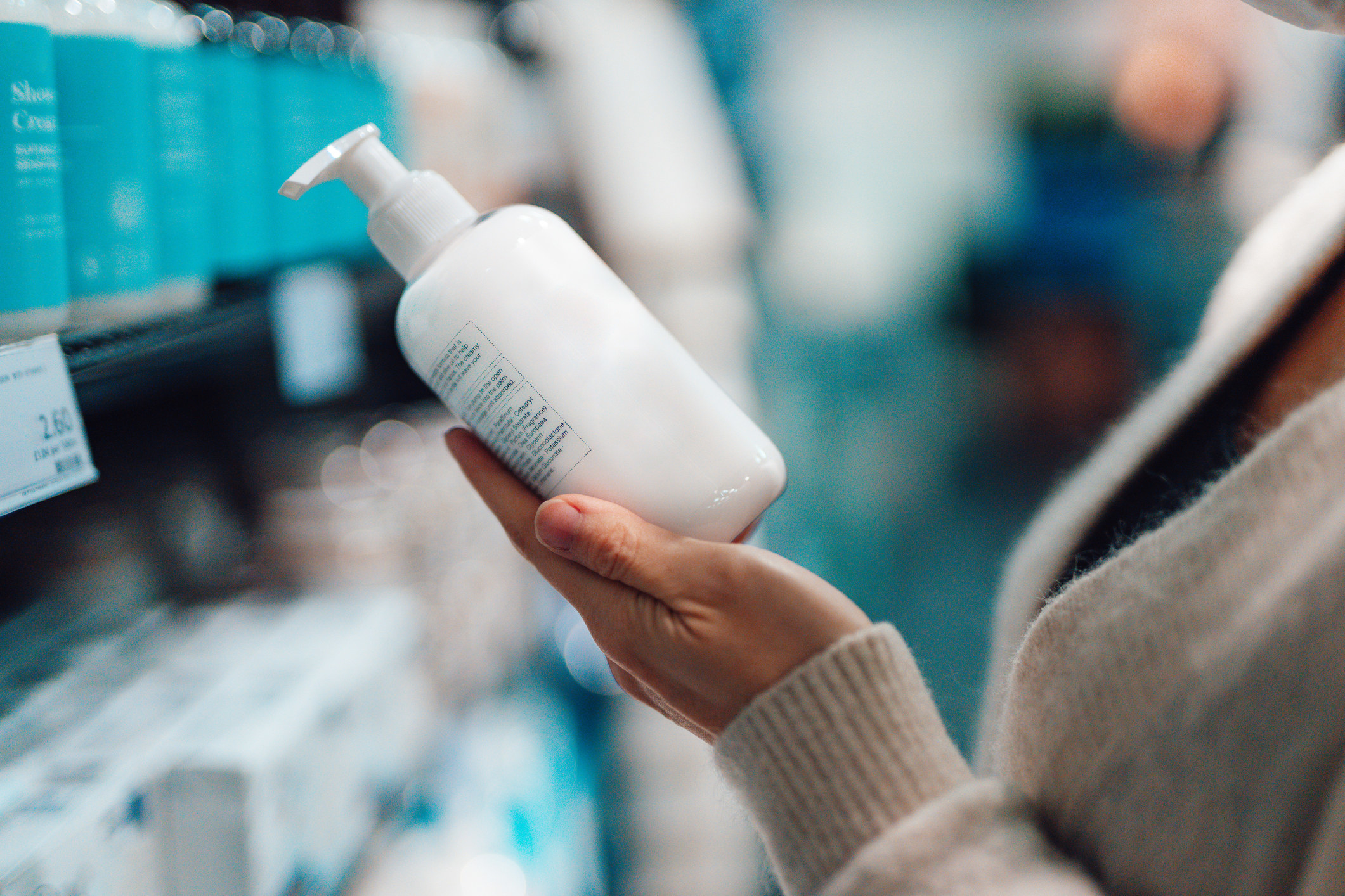 Close up shot of a woman holding a lotion bottle.