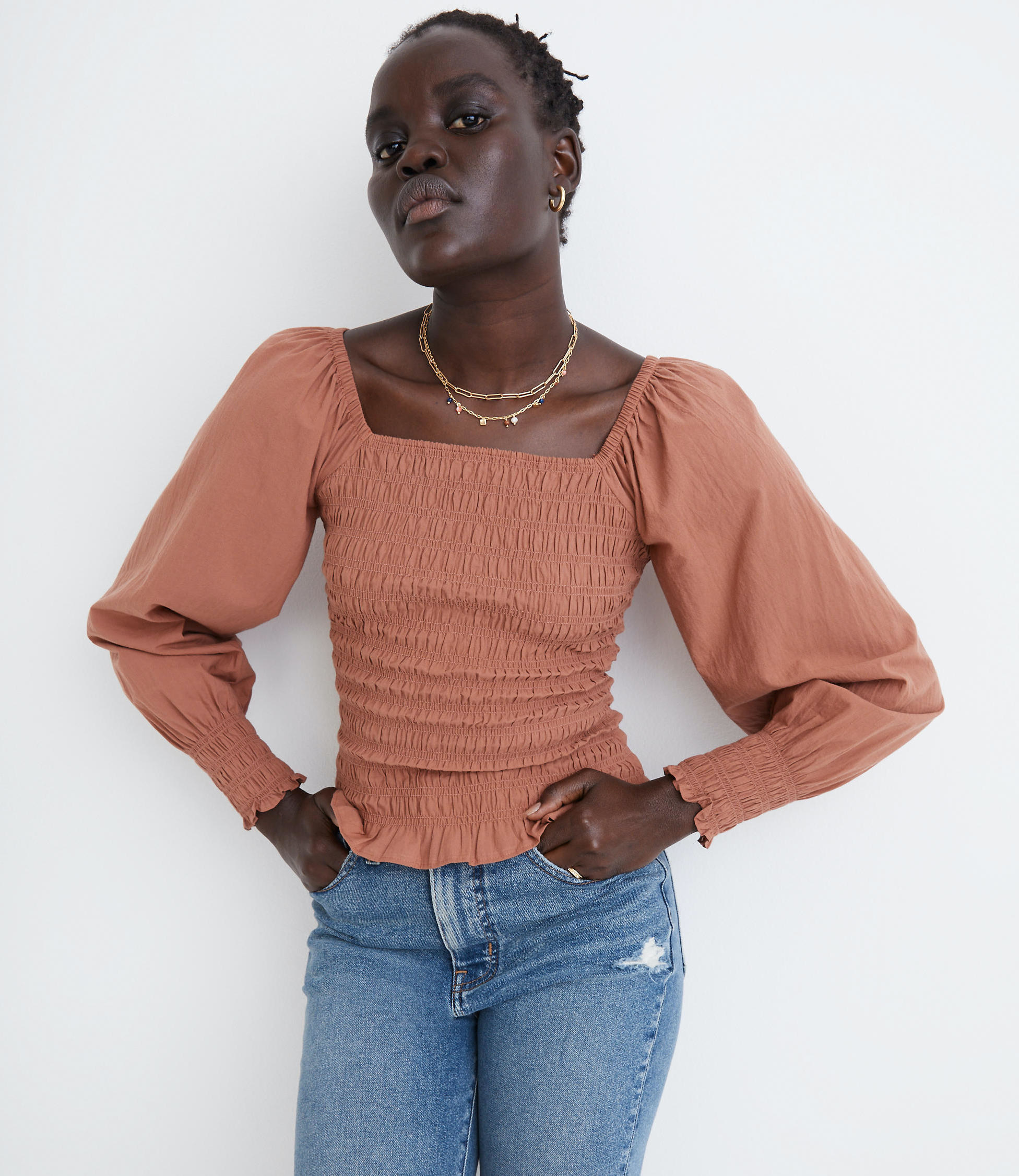 Model wearing orange top with jeans