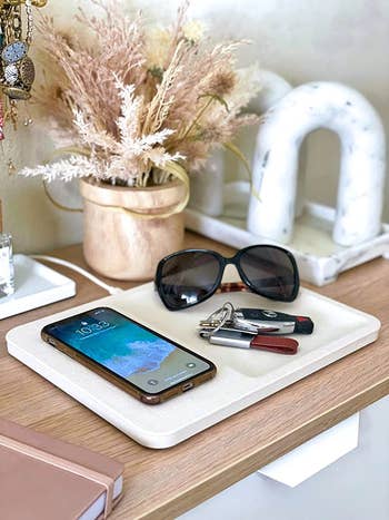 reviewer photo of their charging station with a phone, sunglasses, and keys on top