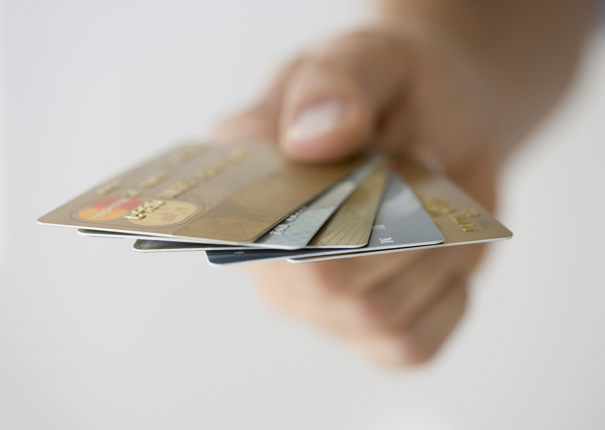 Hand holding fanned out credit cards.