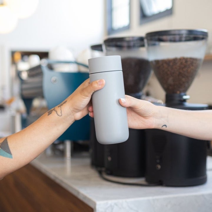 someone handing the sleek tumbler to their friend