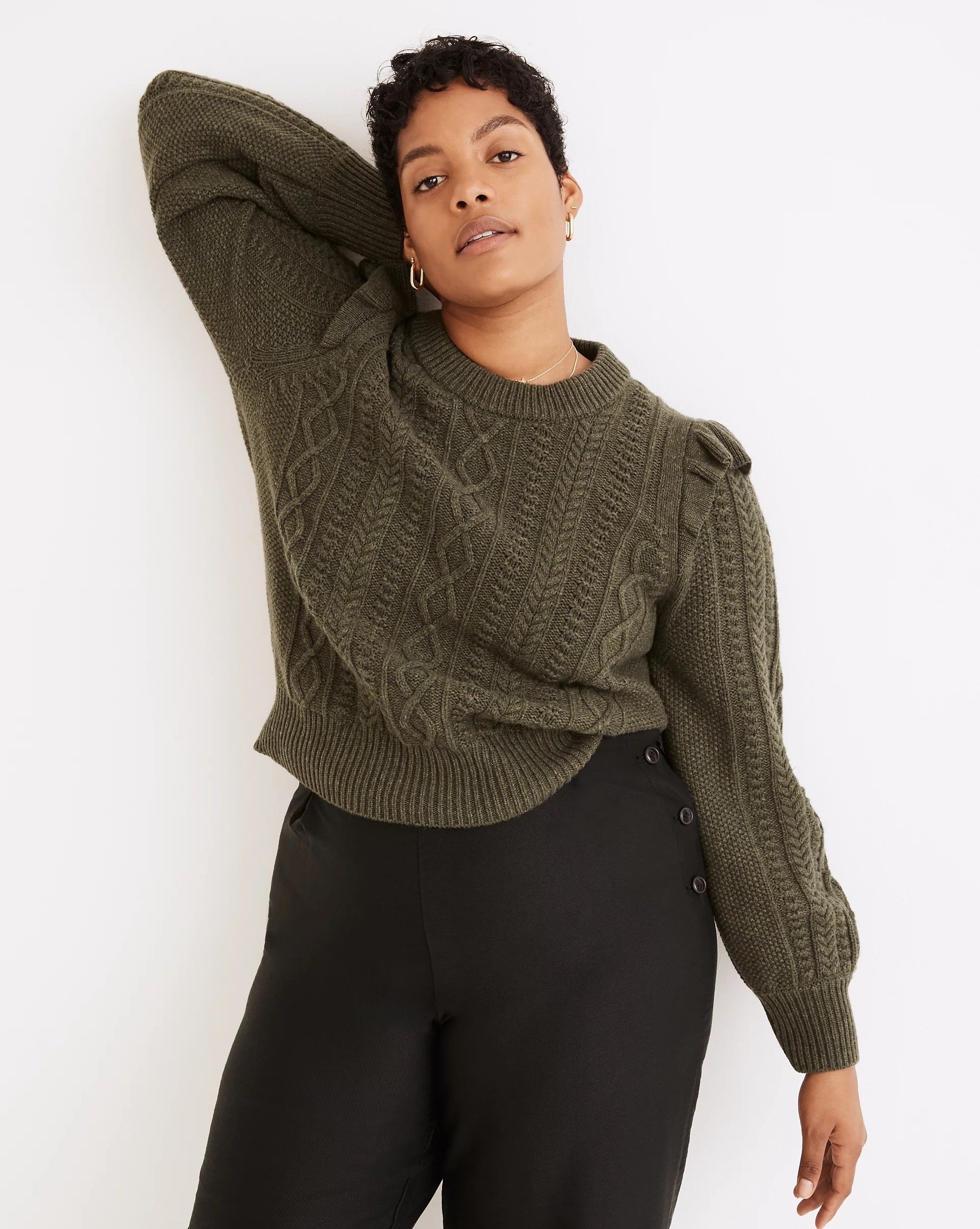 Model wearing green sweater with black pants