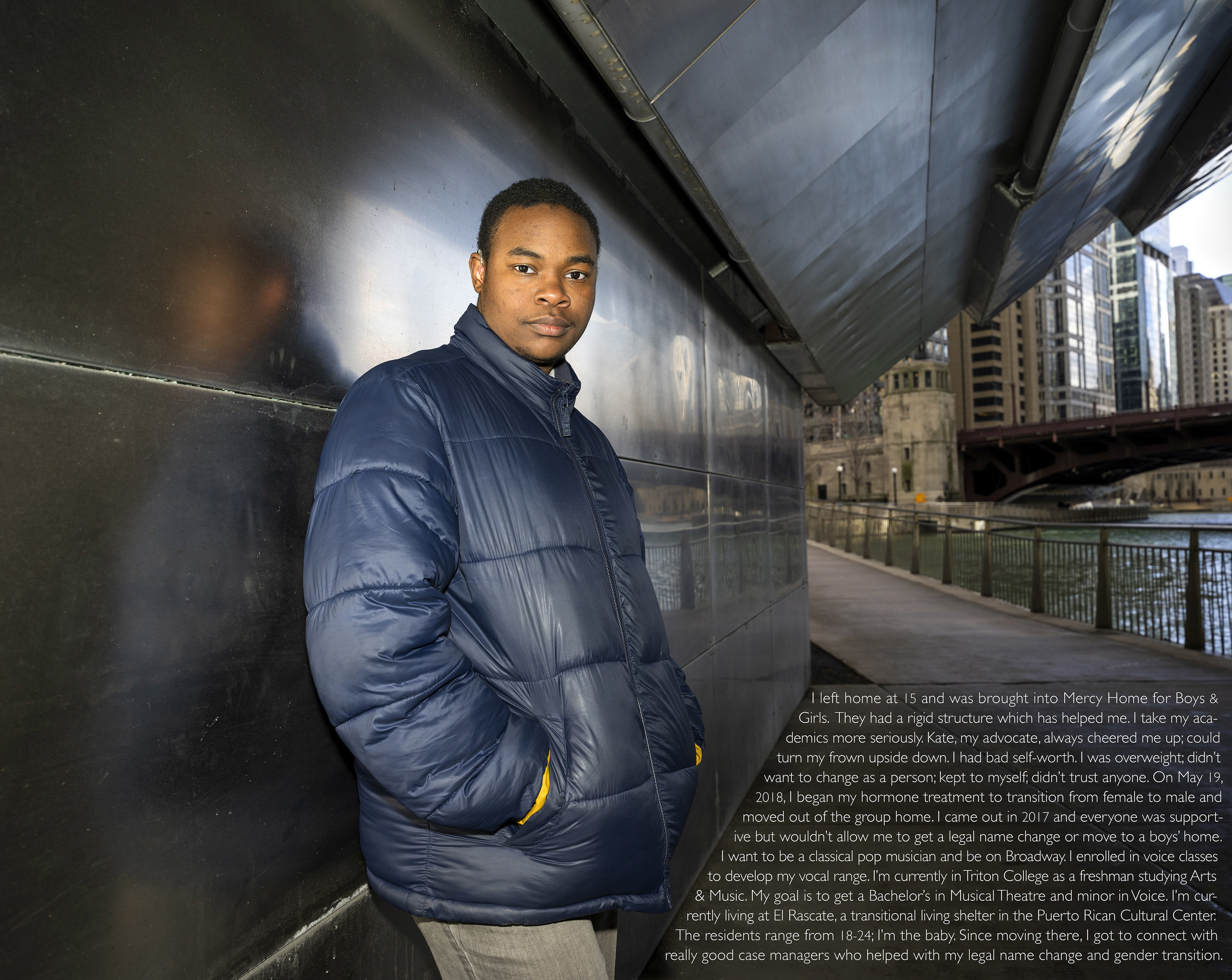 A man stands against a metallic wall outside