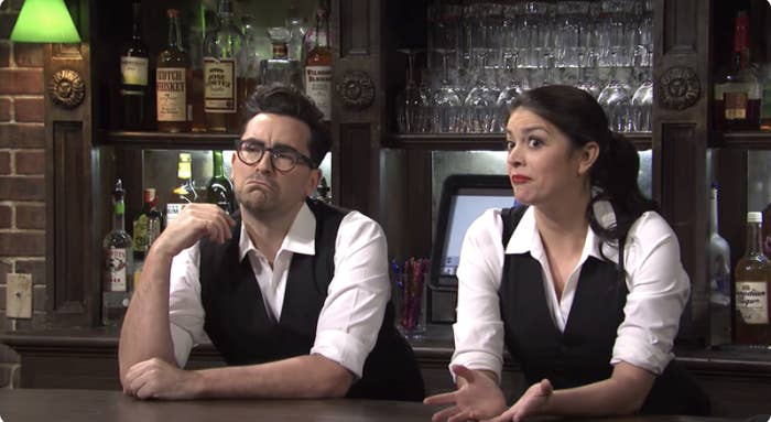 Two bartenders looking judgey towards their customers