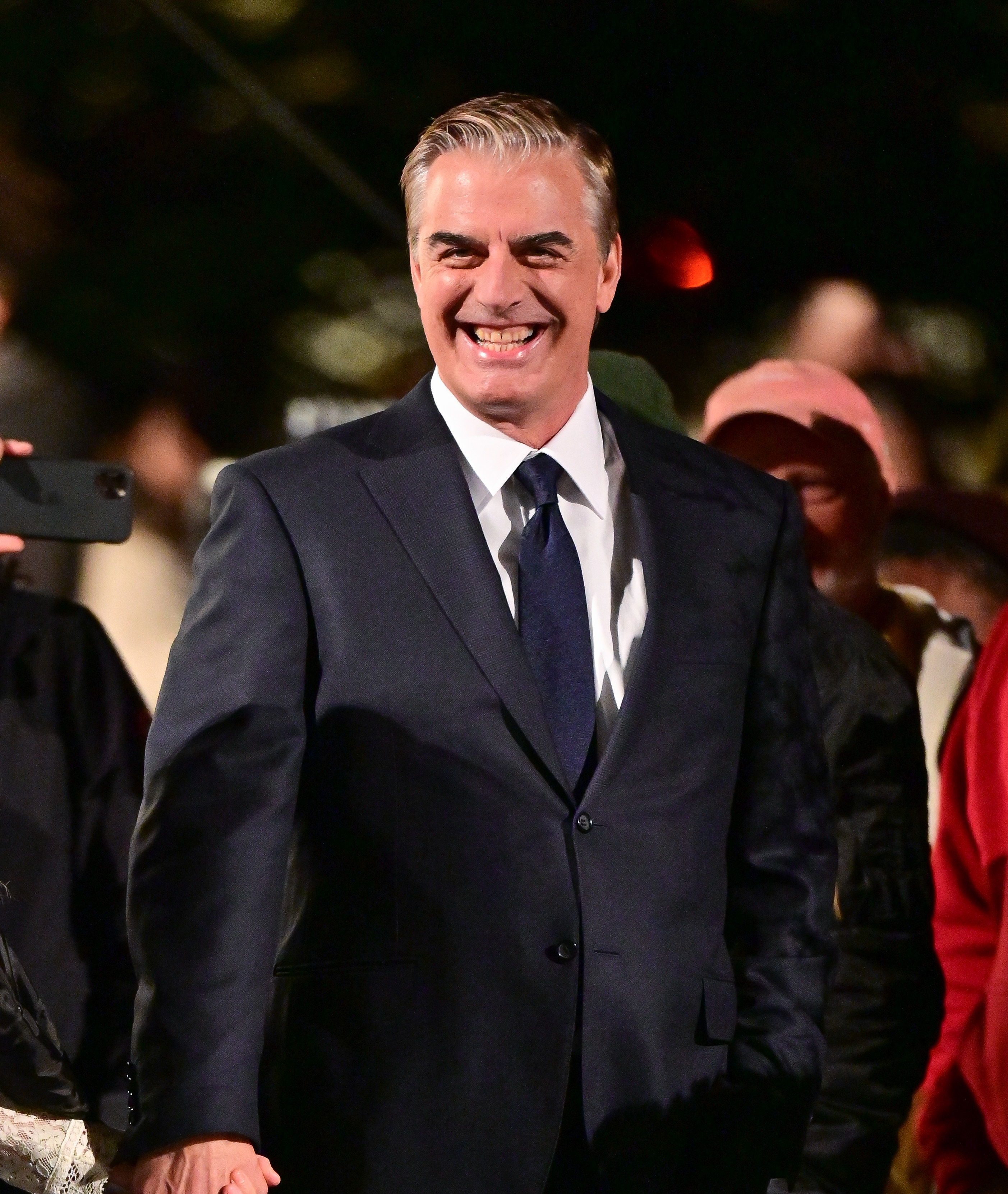 Chris smiling as he walks a red carpet event