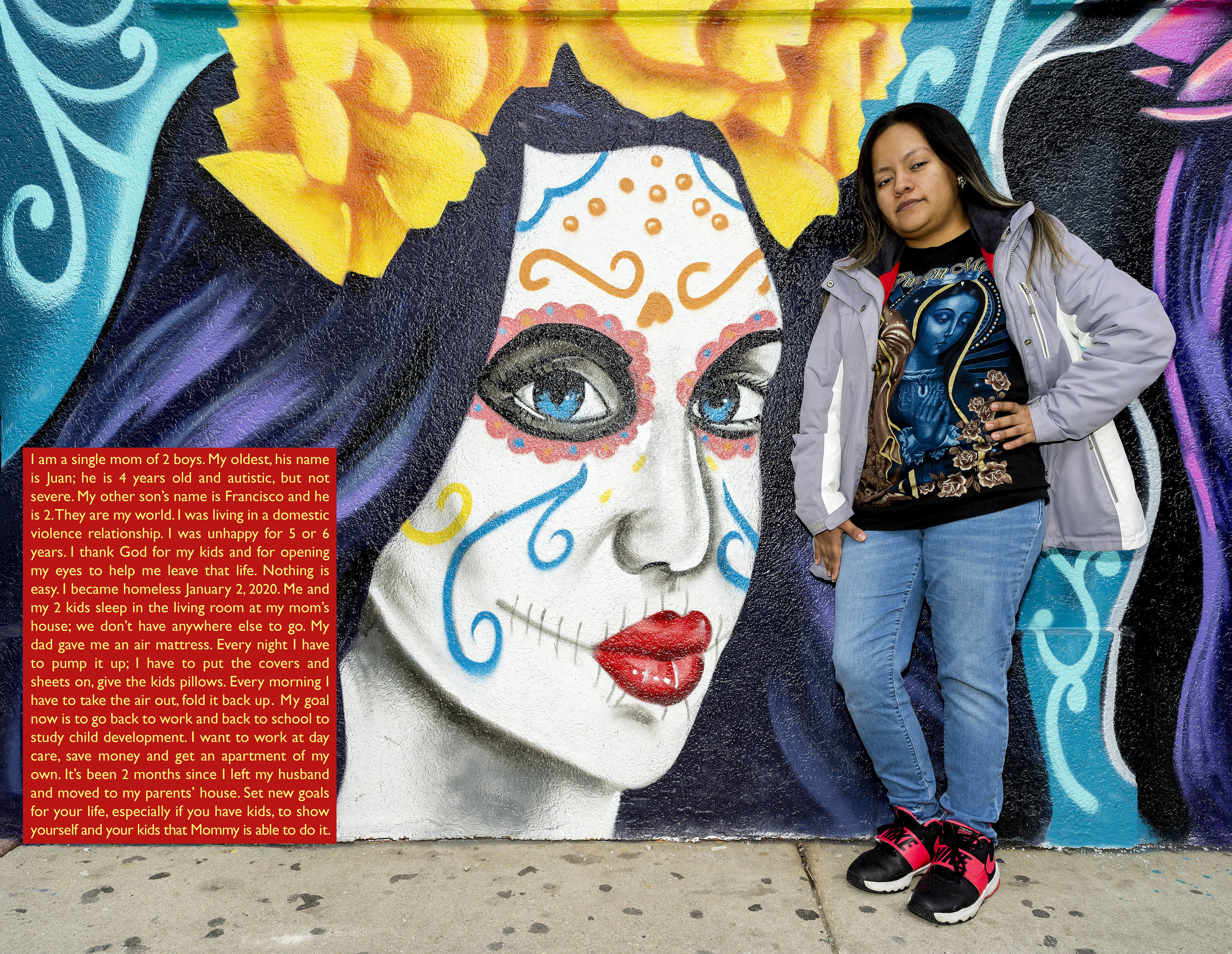A woman leans against a mural