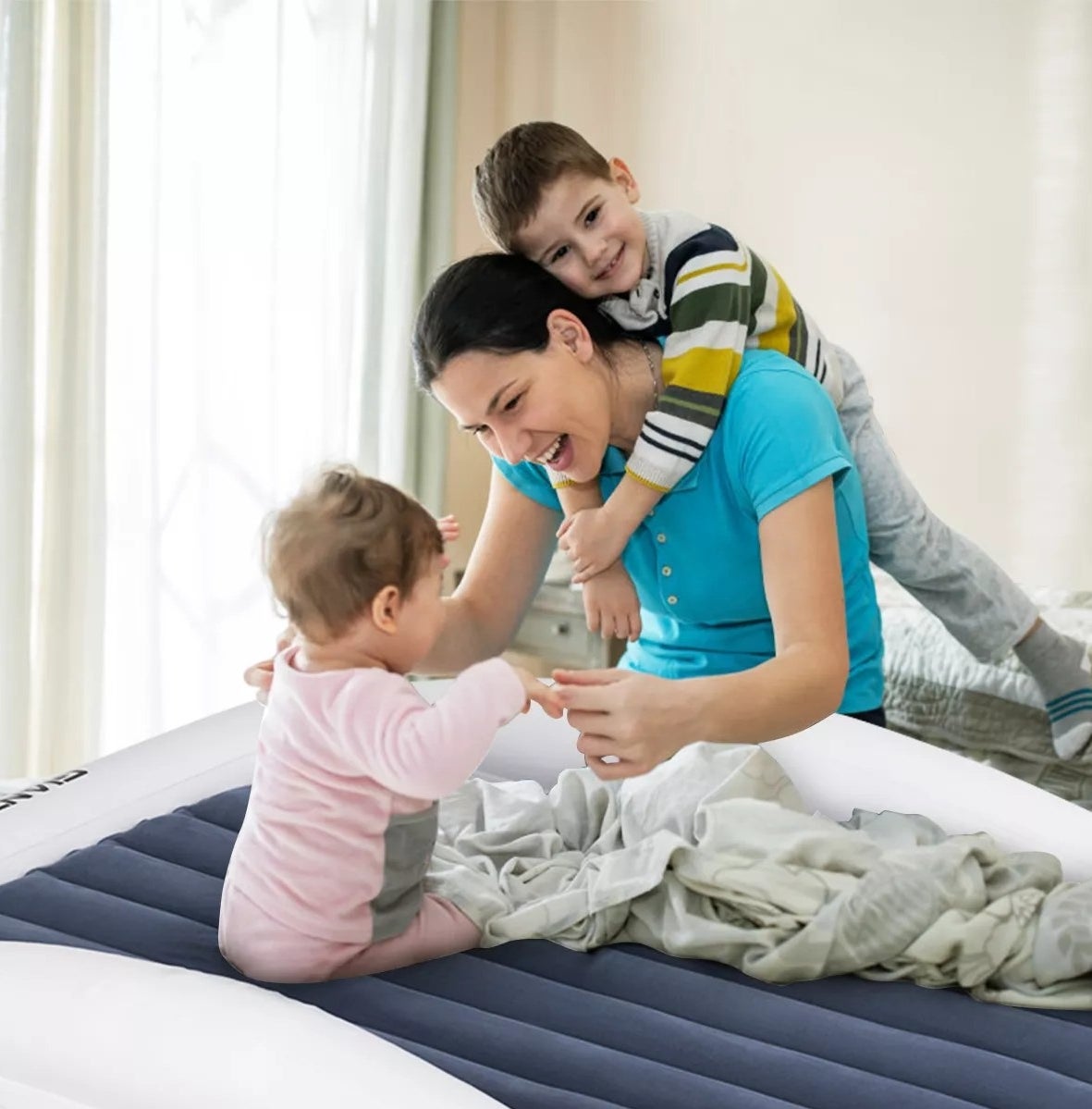 A parent playing with their infant on the inflatable bed