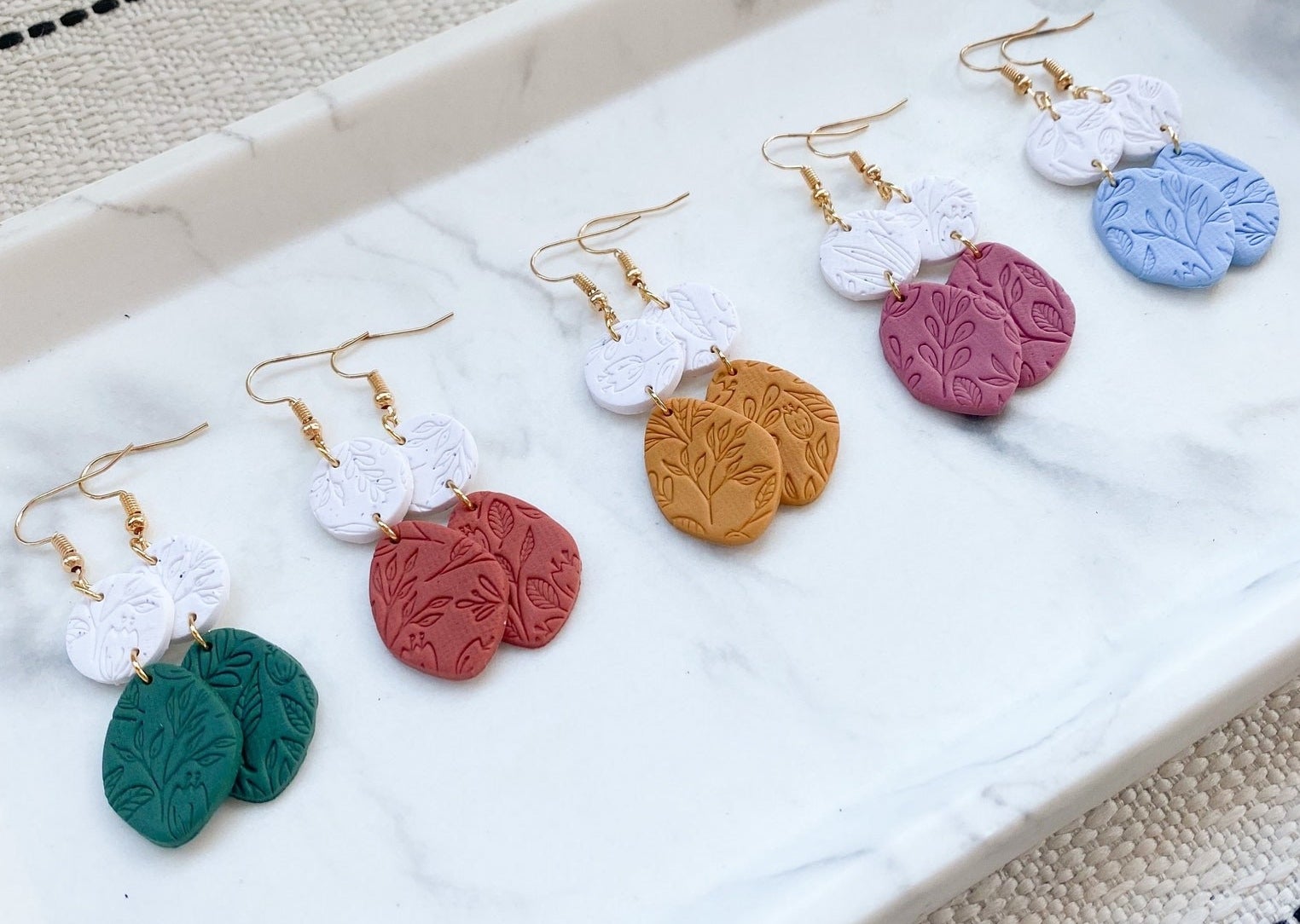 Earrings with floral imprints in a range of color options.