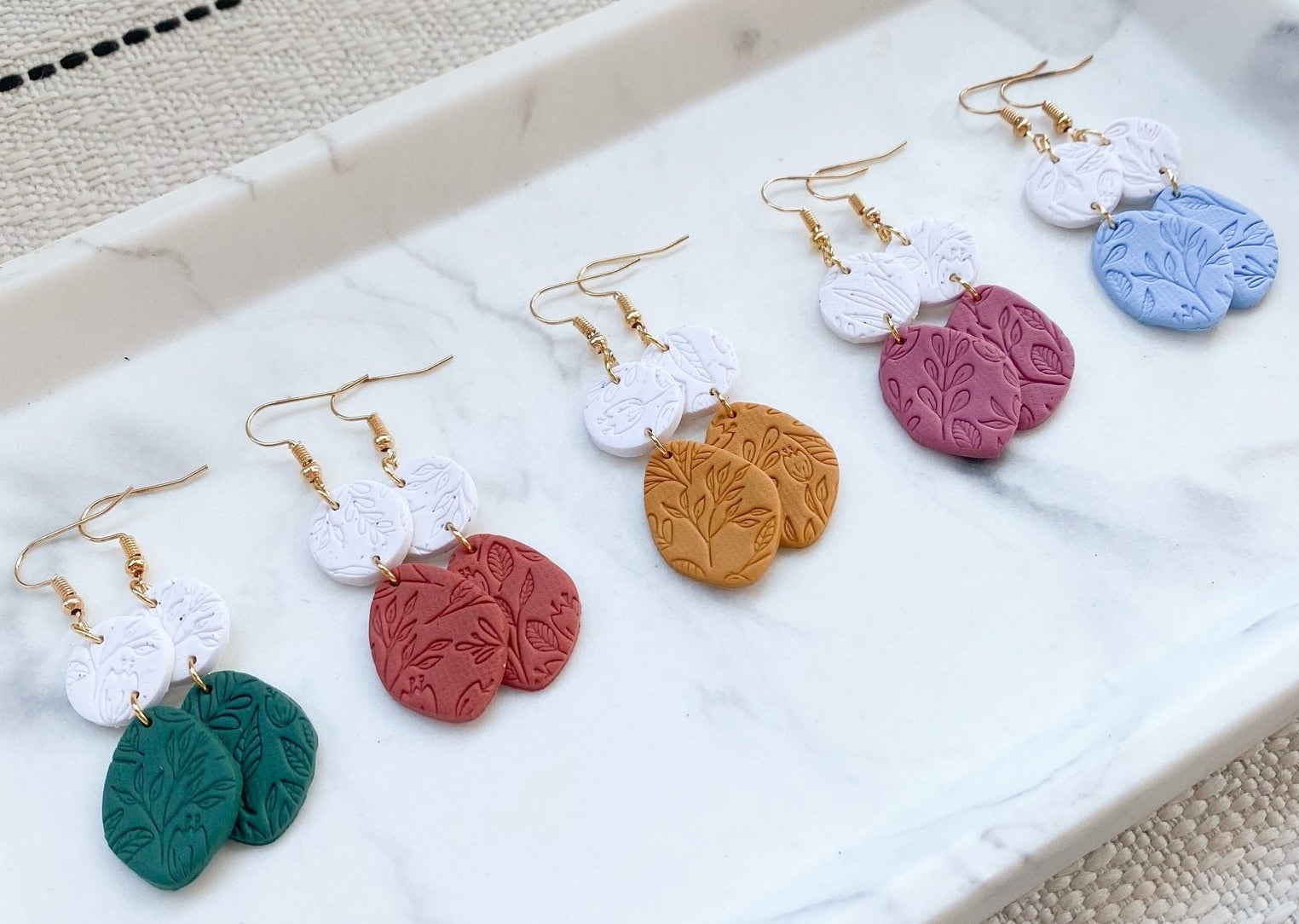 Earrings with floral imprints in a range of color options.