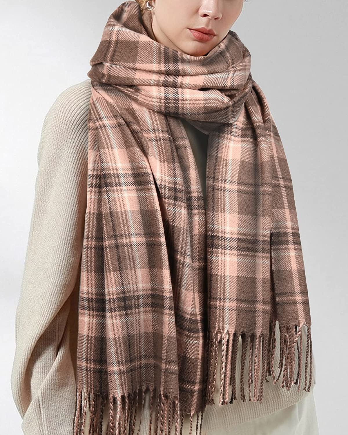 A model wearing a brown and pink plaid scarf