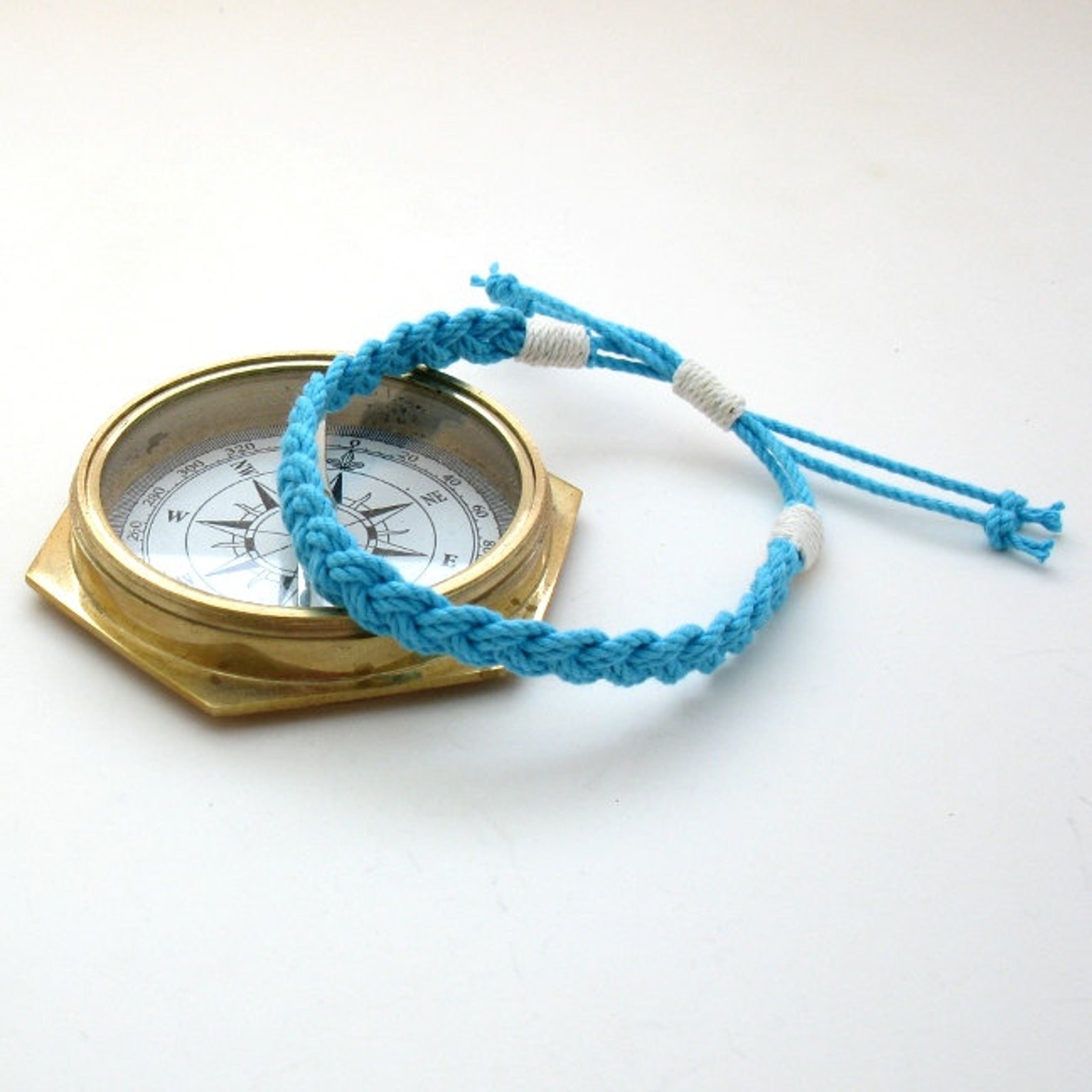 A turquoise anklet set on a compass.