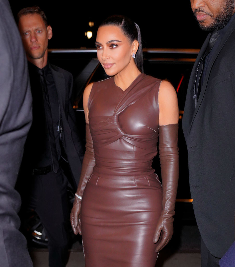 Kim in a leather sheath dress and matching gloves