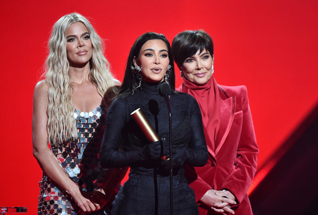 Kim accepting an award with her sister Khloe and mother Kris