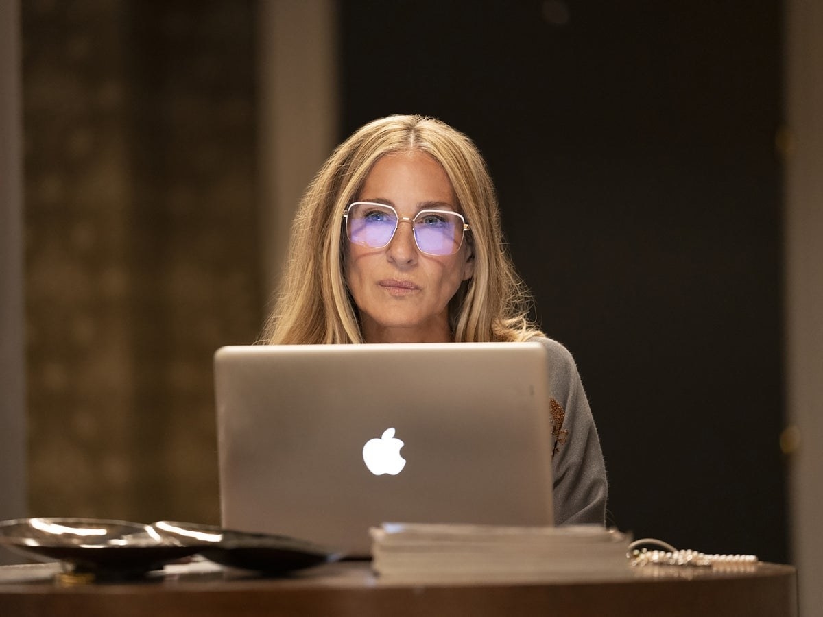 Sarah Jessica Parker as Carrie in And Just Like That... sitting at her desk typing on a MacBook