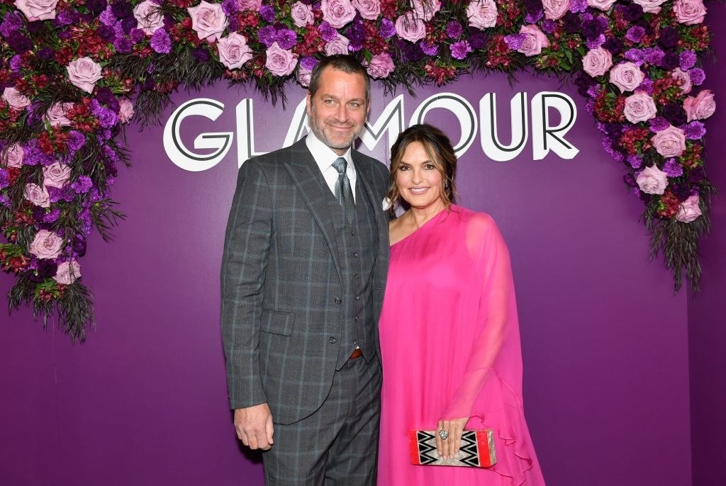 Peter Hermann and Mariska Hargitay posing in front of the Glamour press wall