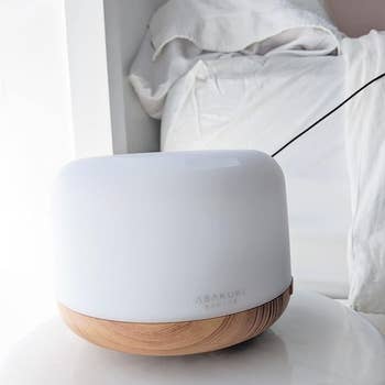 a reviewer's white diffuser sitting on a nightstand.