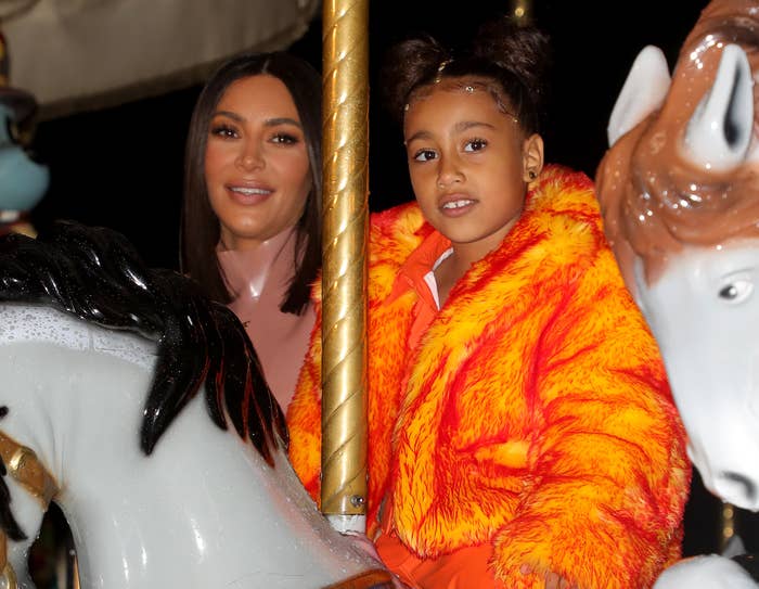 North smiles while riding a merry go round with Kim