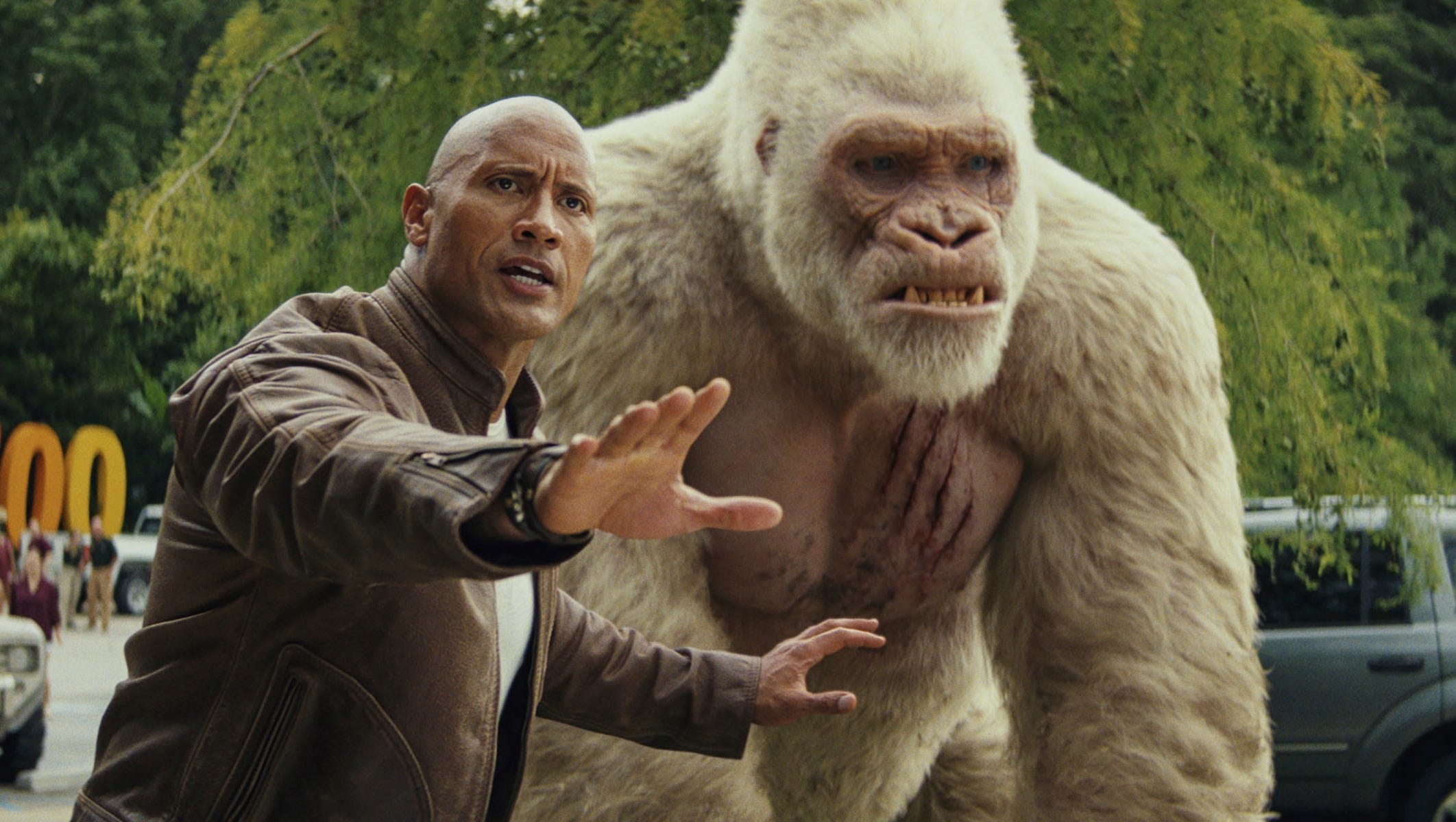 dwayne johnson tries to protect george the giant ape with his giant hand
