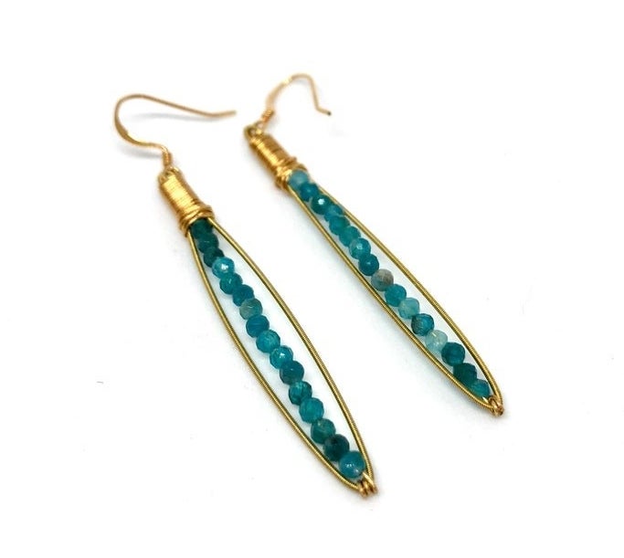 A pair of guitar string earrings with beaded centers.