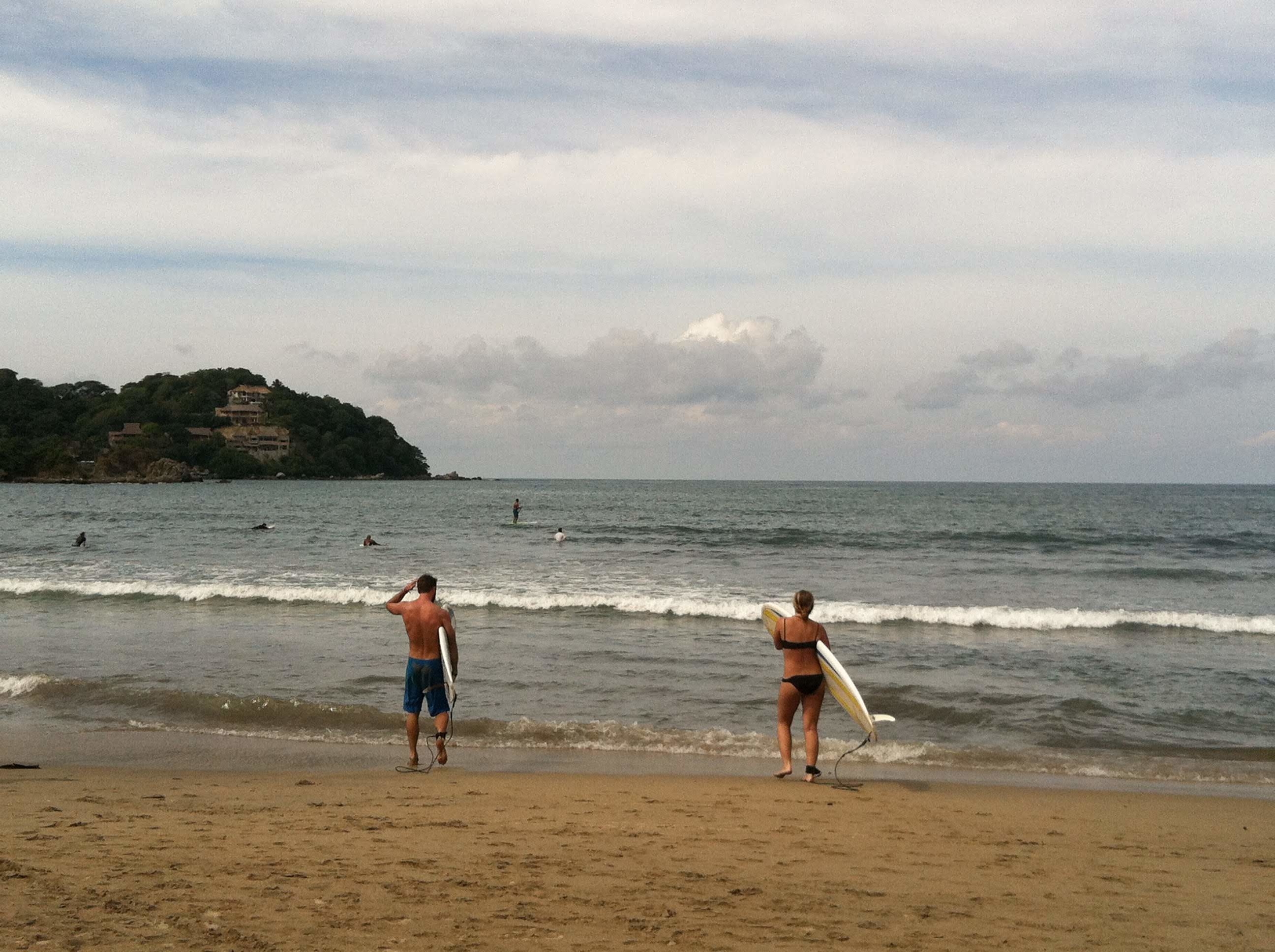 Two people getting ready to go surfing in Sayulita