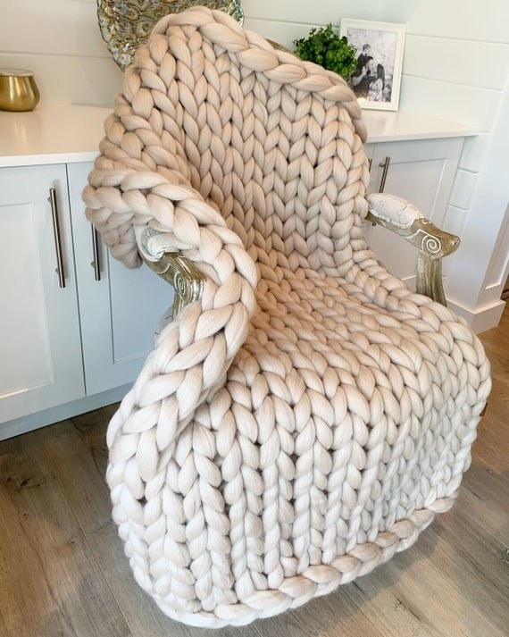 An off-white chunky knit blanket