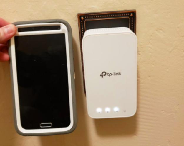 the extender with a phone held up next to it for scale, they are the same size roughly