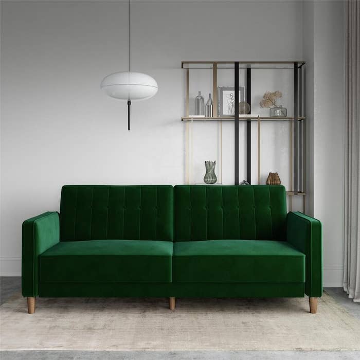 the green velvet sofa in a decorated room