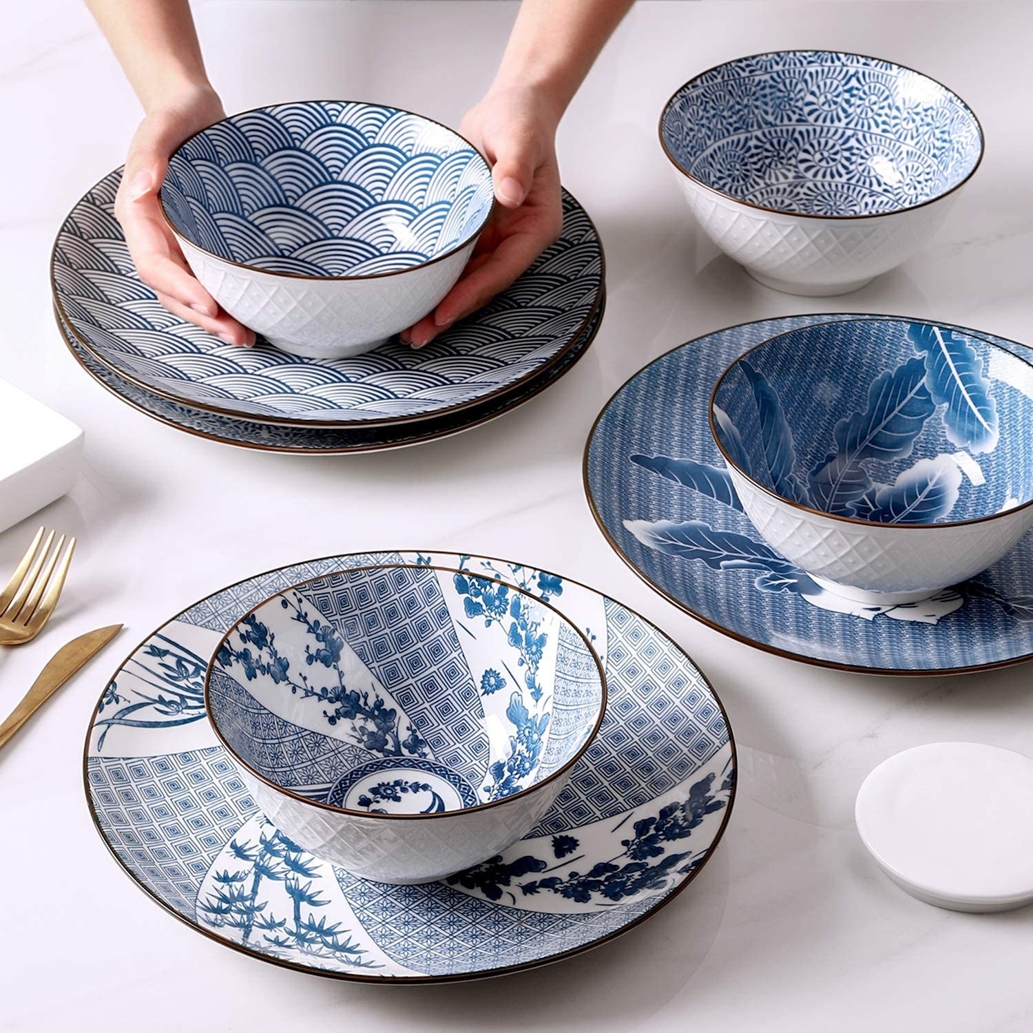Four bowls on matching plates, a person is holding on