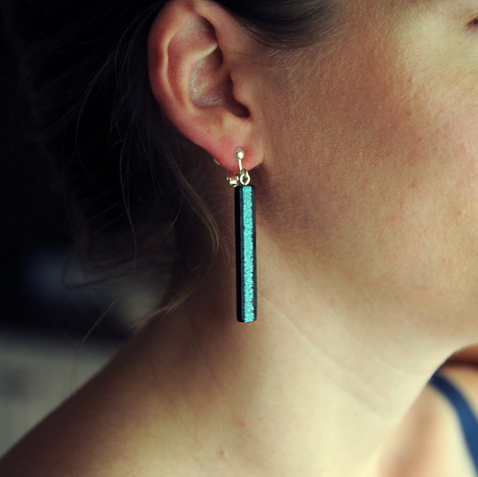A person wearing the turquoise earrings.