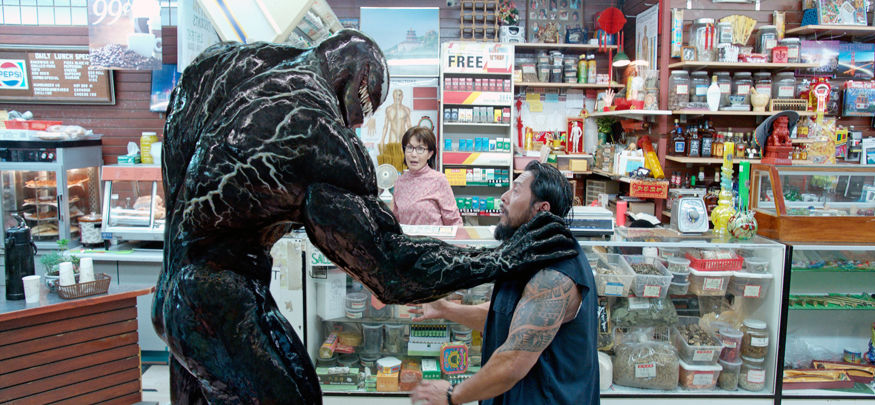 Venom grabbing a man by the throat in a convenience store