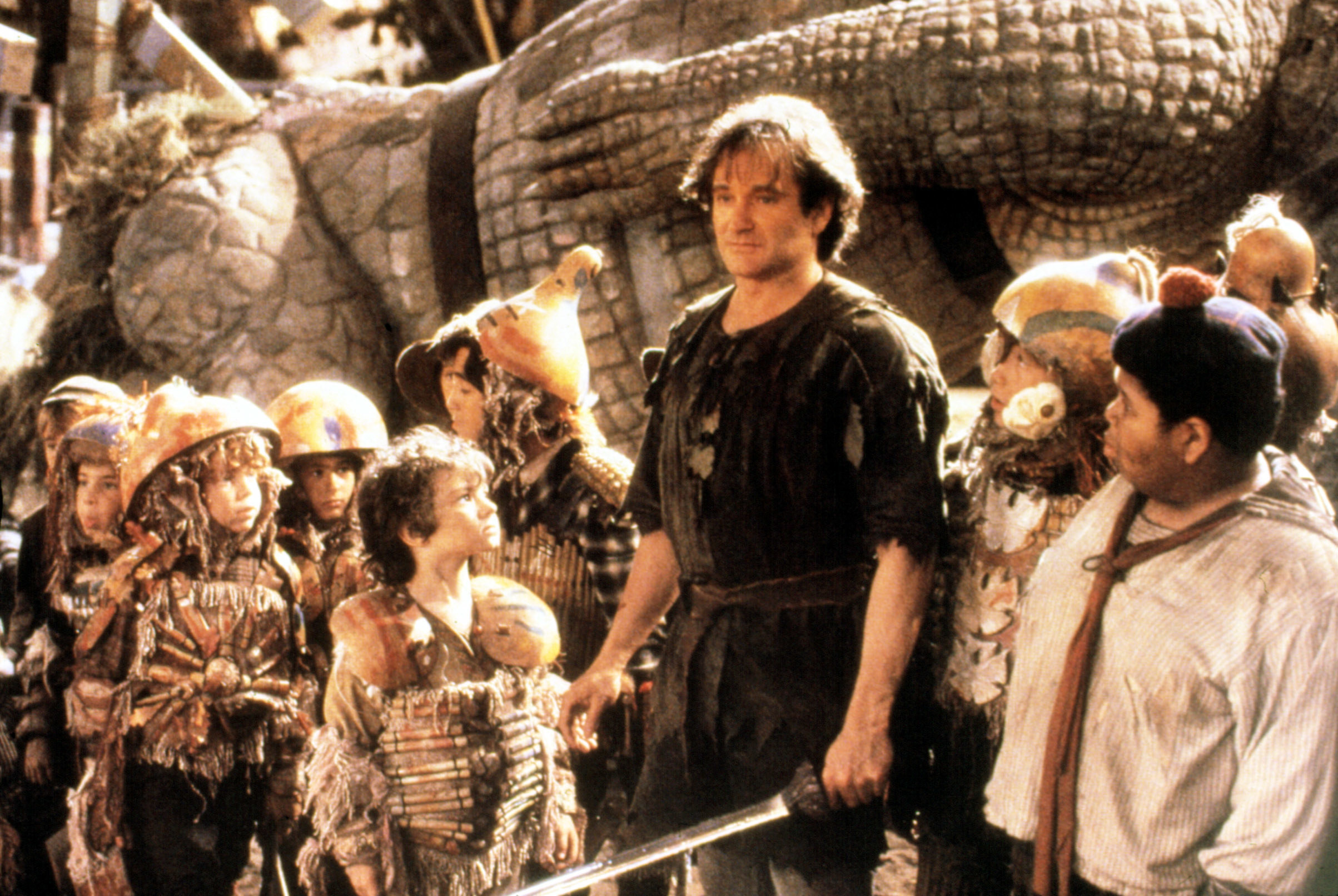 Robin Williams as Peter Pan standing with the Lost Boys