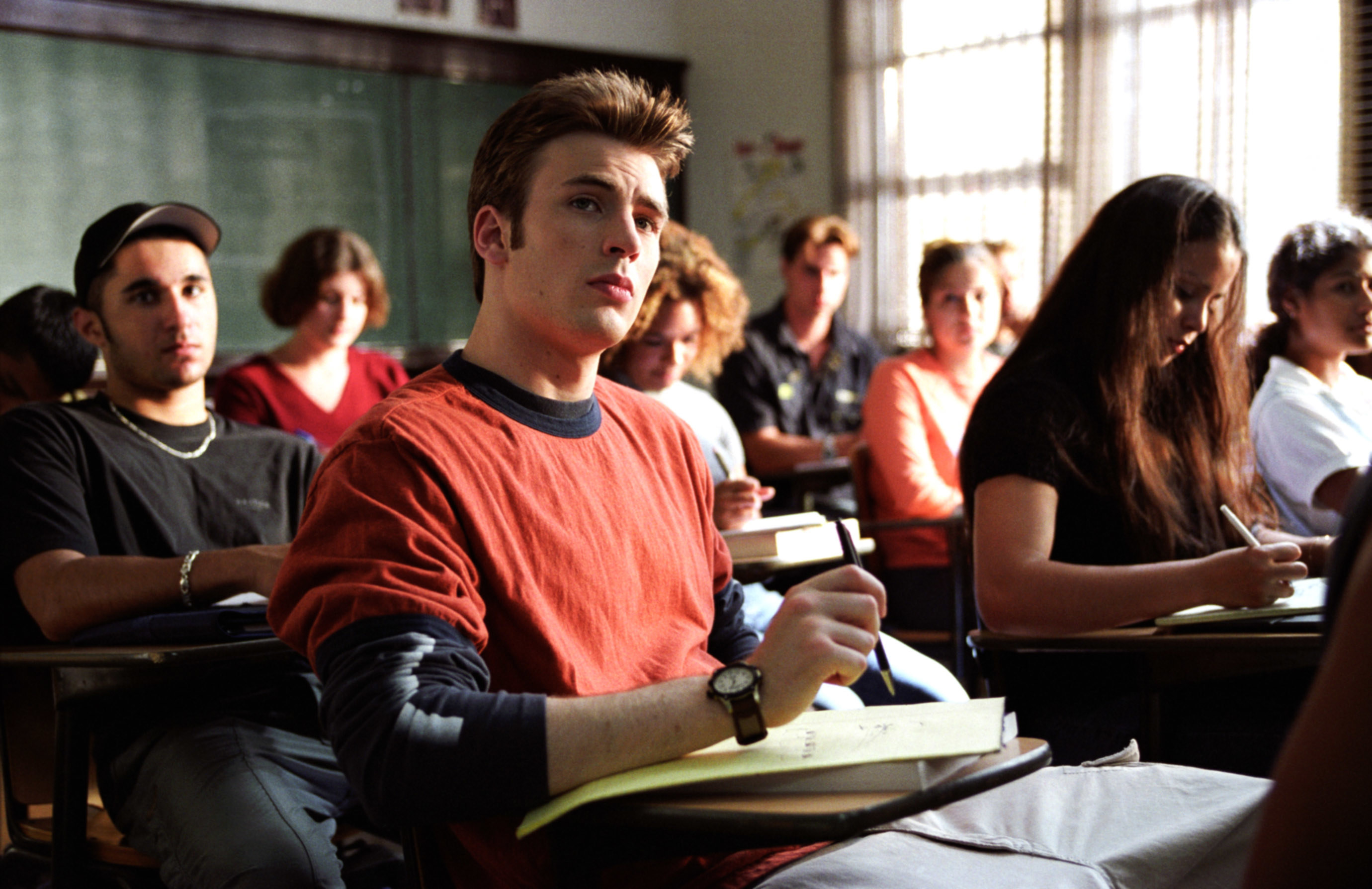 Chris Evans in a scene from the movie sitting in a classroom and taking notes