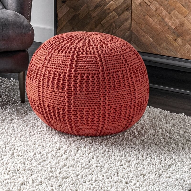 the orange pouf in a living room