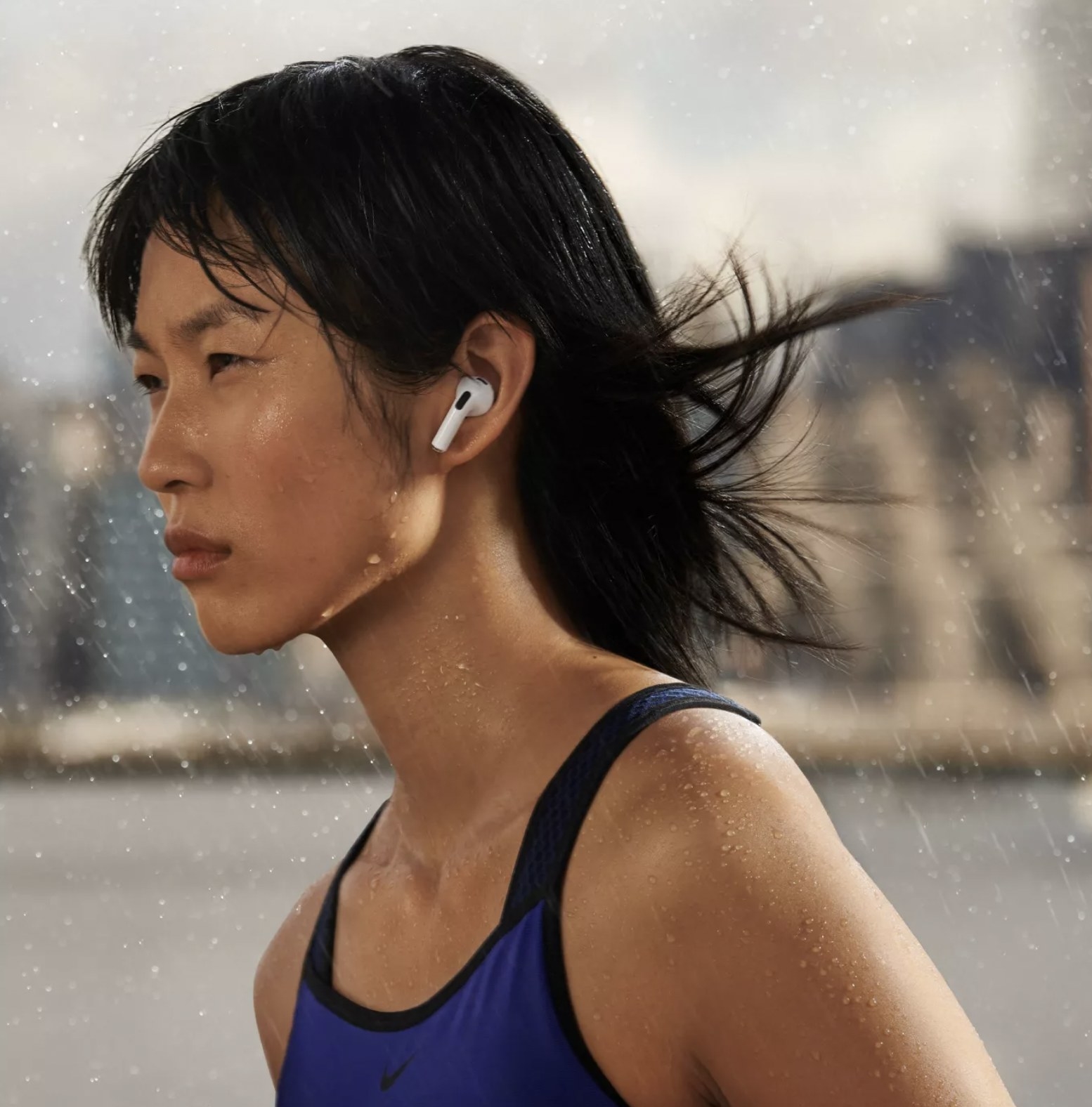 Model running in the rain with the airpods in her ear