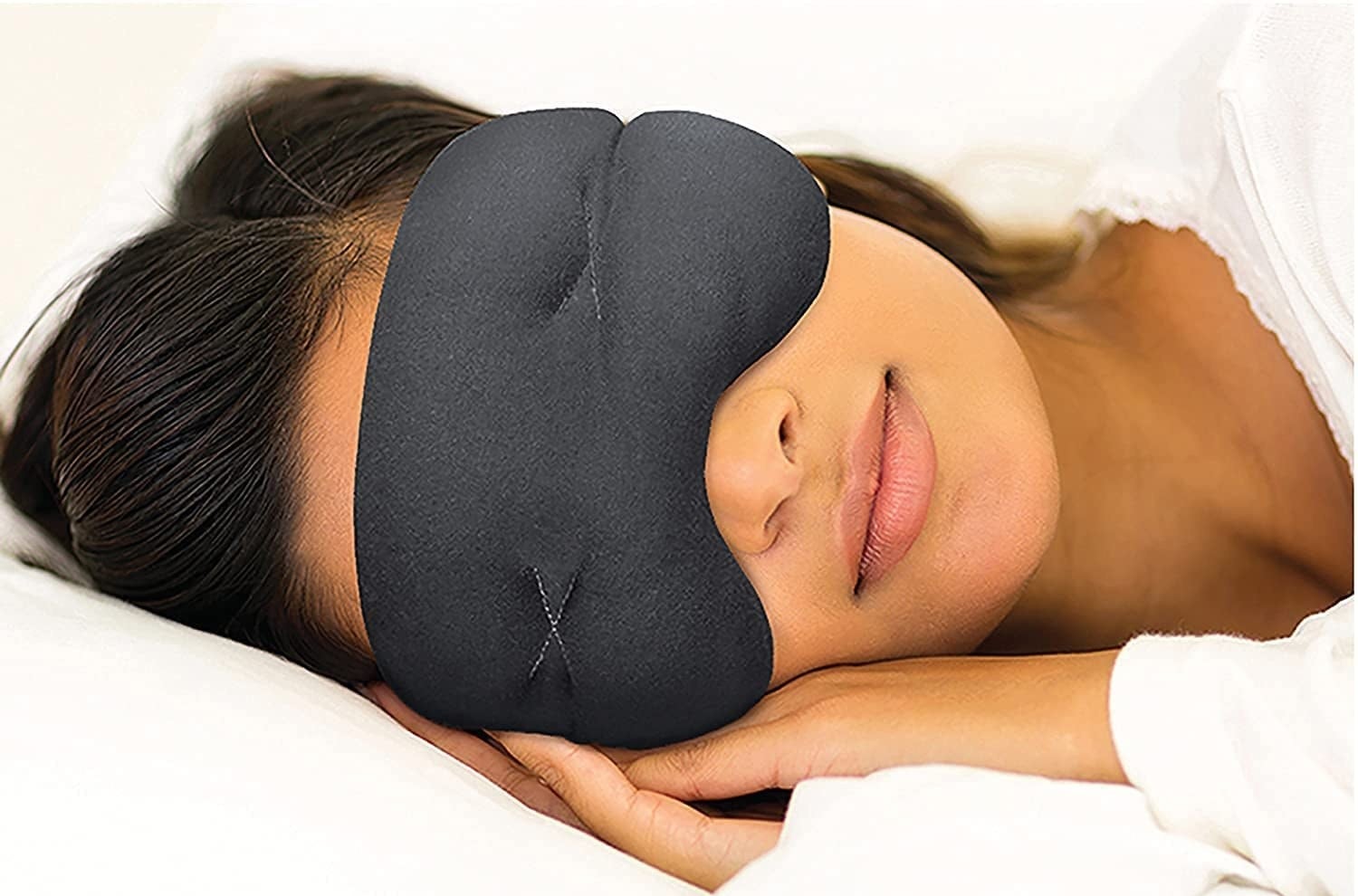 a model sleeps with the gray mask while laying down