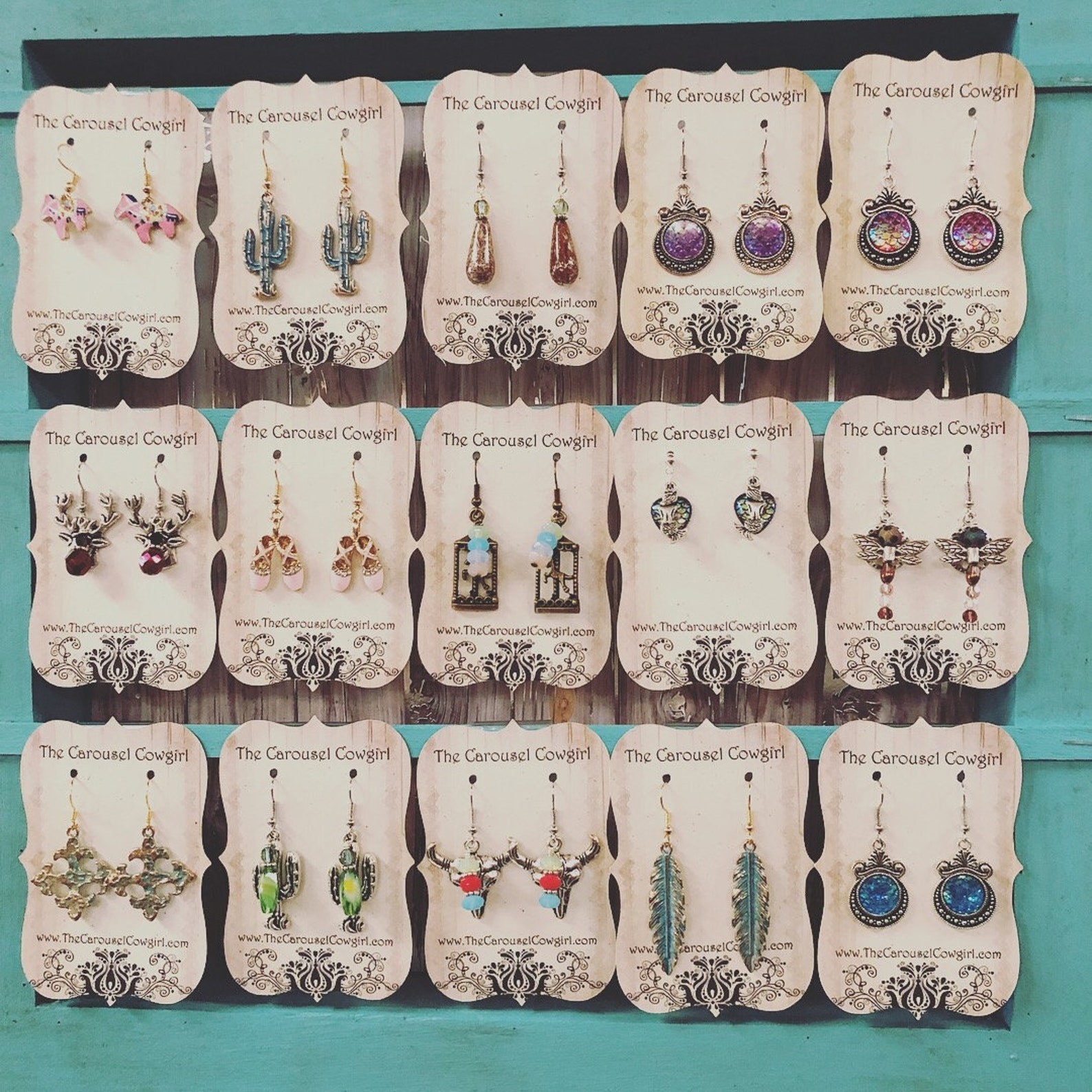 Fifteen assorted pairs of earrings hanging on an earring holder