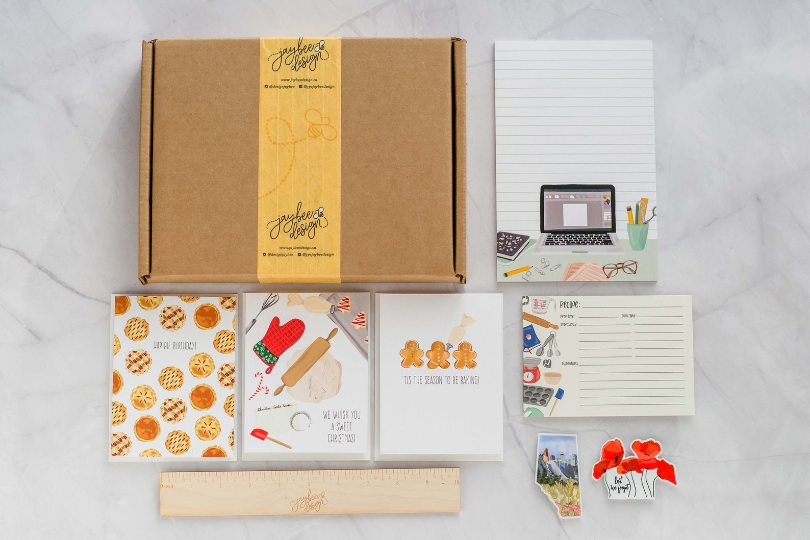 The Paper Bee subscription box and its contents, including baking-themed greeting cards, notepads, and stickers