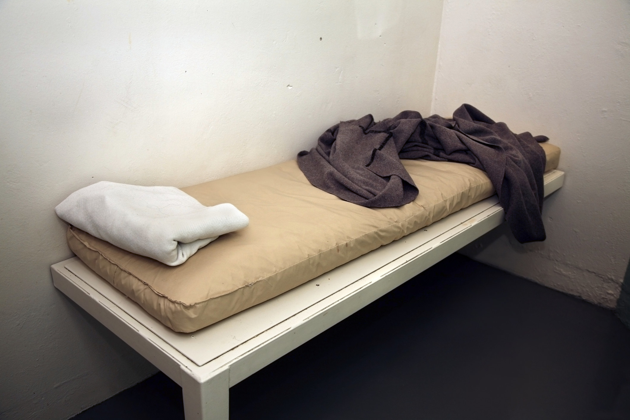 A simple bed in an empty cell