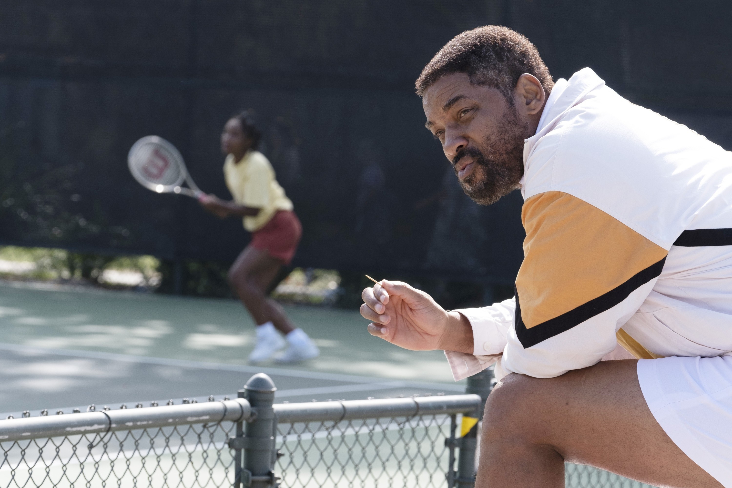 Will Smith holds a toothpick while watching tennis