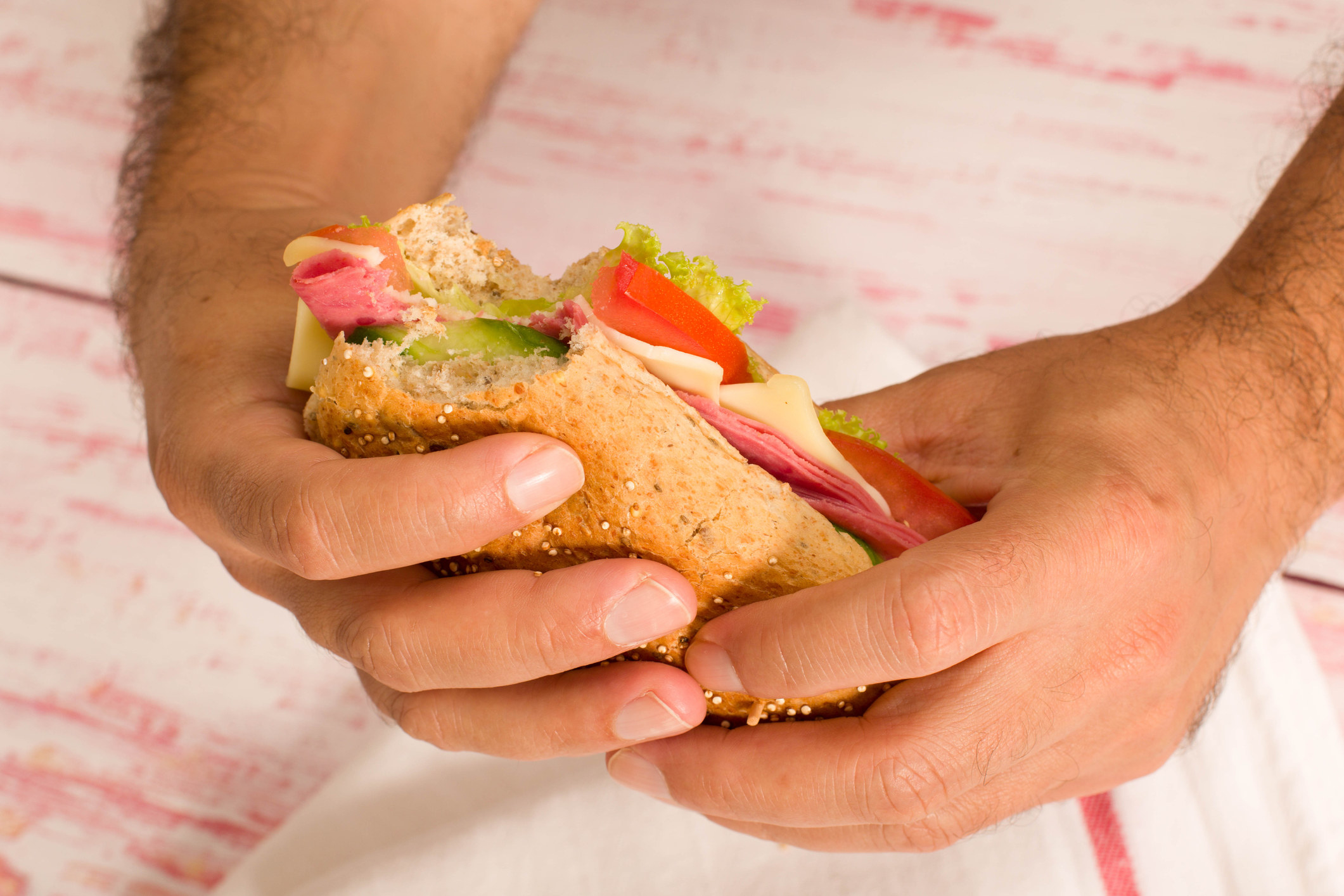 A hand holding a sandwich
