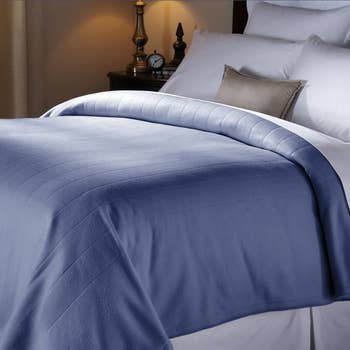 A blue Sunbeam electric blanket on a bed