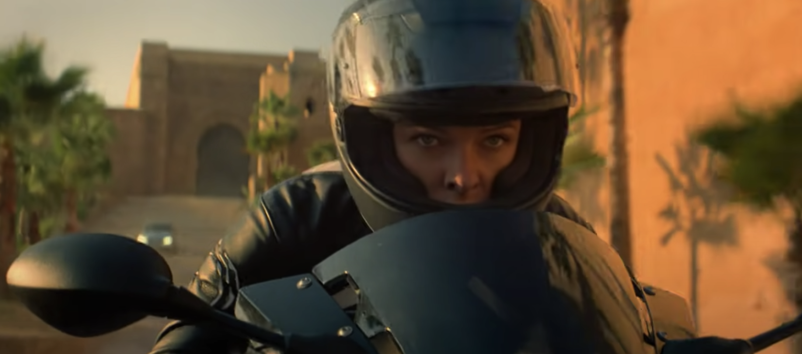 A person wearing a helmet on a motorcycle with eyes bare