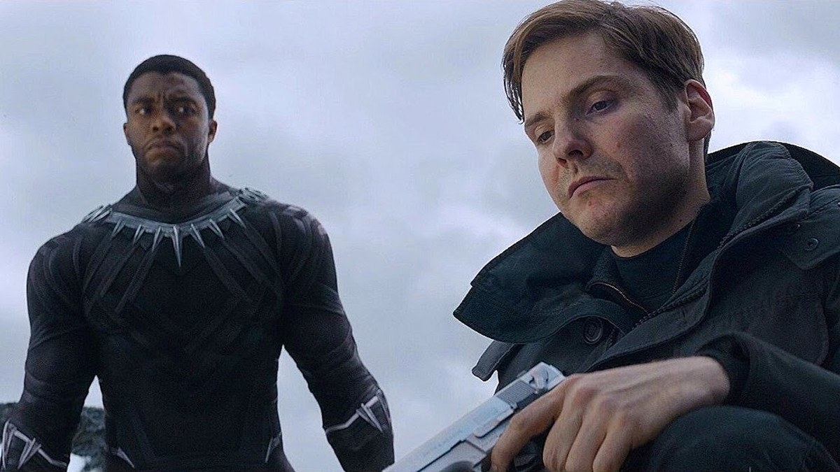 baron zemo holds a gun as black panther watches him