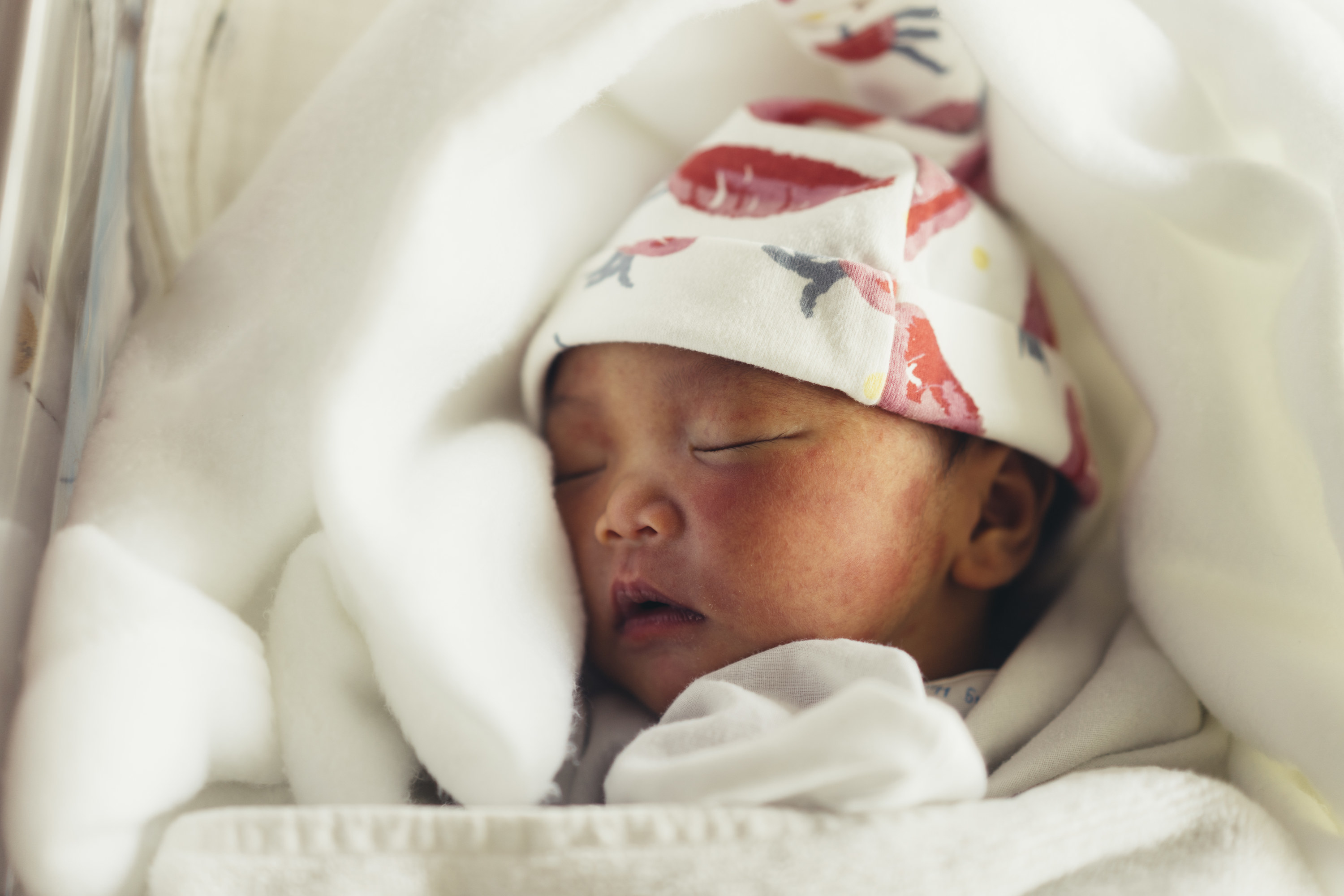 A newborn baby swaddled with a hat on
