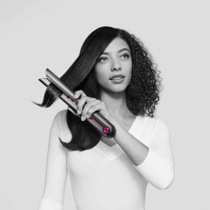 Woman straightening hair with Dyson&#x27;s Corrale Straightener